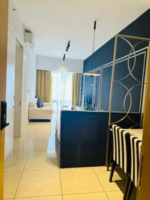 a living room with a blue wall and a kitchen at Bukit Bintang Axon Residence By TRX in Kuala Lumpur