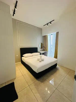 a bedroom with a large white bed and a window at Bukit Bintang Axon Residence By TRX in Kuala Lumpur