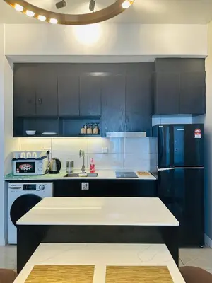 a kitchen with black cabinets and a black refrigerator at Bukit Bintang Axon Residence By TRX in Kuala Lumpur
