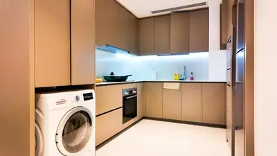 a kitchen with a washing machine and a washer at Eaton Residence KLCC - Royal Home in Kuala Lumpur