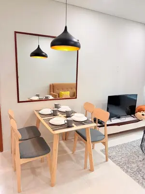 a dining room with a table and chairs and a tv at Sky Suites KLCC by Apartment TD Luxury in Kuala Lumpur