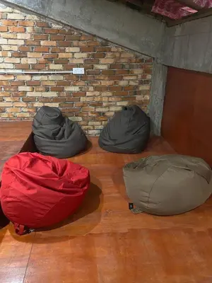 three bean bags sitting on the floor next to a brick wall at China Town Dorm by ichiro in Kuala Lumpur