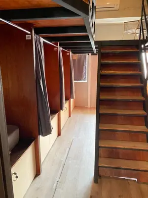 a staircase in a room with clothes hanging on a clothes line at China Town Dorm by ichiro in Kuala Lumpur