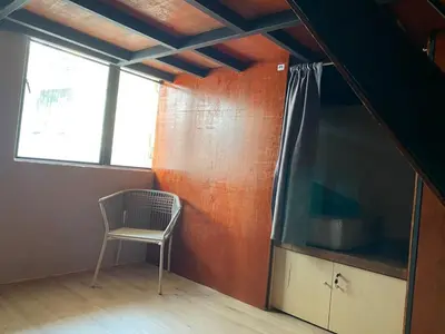 a room with a chair and a large screen tv at China Town Dorm by ichiro in Kuala Lumpur