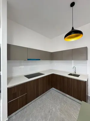 a kitchen with wooden cabinets and a sink and a light at star resdence in Kuala Lumpur