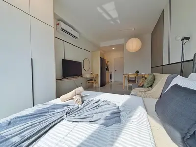 a bedroom with a large bed and a living room at KLCC View Majestic Lovely Studio with Rooftop Pool in Kuala Lumpur