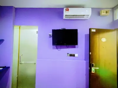 a room with a purple wall with a tv on the wall at Cahaya Hanson BilikXpert in Kuala Lumpur