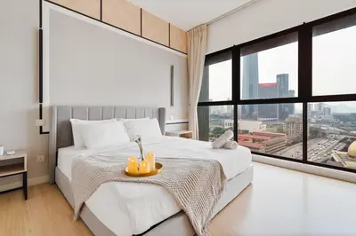 a bedroom with a white bed with a large window at Continew Facing TRX View 10MIN TO KLCC With PS4 in Kuala Lumpur