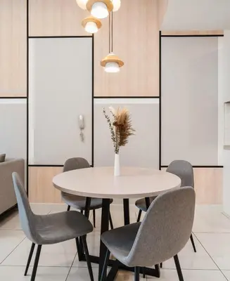a dining room table with chairs and a vase with flowers at Continew Facing TRX View 10MIN TO KLCC With PS4 in Kuala Lumpur