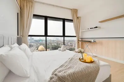 a bedroom with a white bed with a large window at Continew Facing TRX View 10MIN TO KLCC With PS4 in Kuala Lumpur