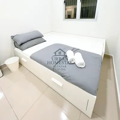 a white bed in a white room with towels on it at Urban Homestay Setapak MHP2 Kids Friendly in Kuala Lumpur