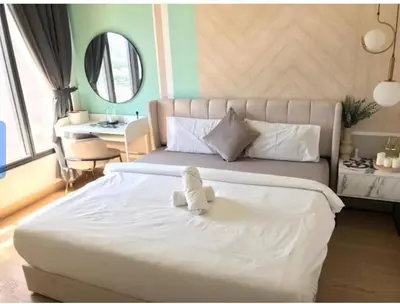 a white teddy bear sitting on top of a bed at Lucentia Residence in Kuala Lumpur