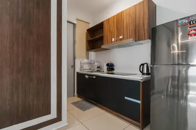 a kitchen with a stainless steel refrigerator and wooden cabinets at Luxury 3Bedroom Kenwingston Platz 15Mins To KLCC Fit 9Pax A15 in Kuala Lumpur
