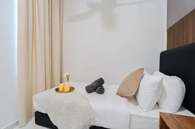 a room with a bed with a table and pillows at Kenwingston Platz Facing KLCC VIEW 15Mins To KLCC Fit 9Pax A24 in Kuala Lumpur