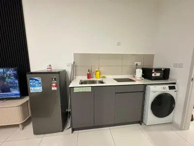 a small kitchen with a sink and a washing machine at Majestic Residence KLCC By MYHOME in Kuala Lumpur
