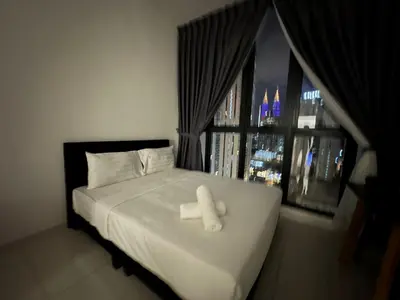 a bed with a white cross on it in front of a window at Majestic Residence KLCC By MYHOME in Kuala Lumpur