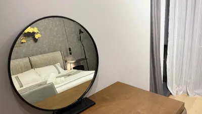 a mirror sitting on a table next to a bed at Star Residance KLCC By Nexus 24 in Kuala Lumpur
