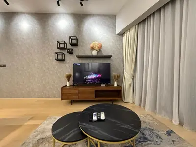 a living room with a tv and a table at Star Residance KLCC By Nexus 24 in Kuala Lumpur