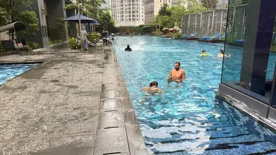 a group of people swimming in a swimming pool at Star Residance KLCC By Nexus 24 in Kuala Lumpur