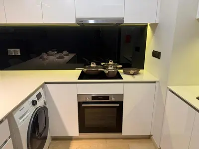 a kitchen with a stove and a washing machine at Star Residance KLCC By Nexus 24 in Kuala Lumpur
