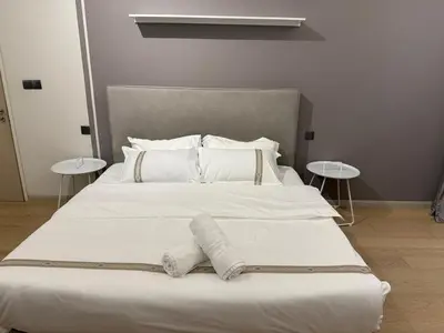 a large white bed with white pillows and two tables at Star Residance KLCC in Kuala Lumpur