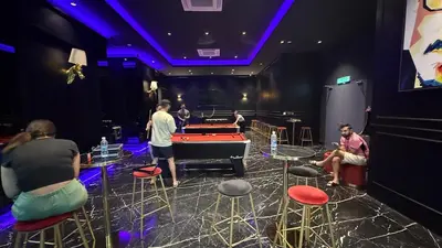 a group of people sitting in a room with a pool table at Star Residance KLCC in Kuala Lumpur
