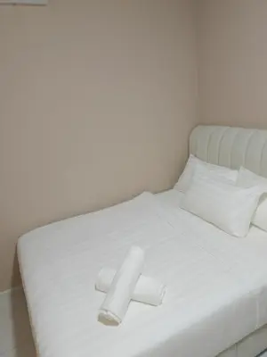a white bed with white sheets and two white pillows at majestic residence klcc rooftop pool in Kuala Lumpur
