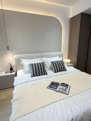 a white bed with two pillows and a book on it at Twin Tower Crush by KF in Kuala Lumpur