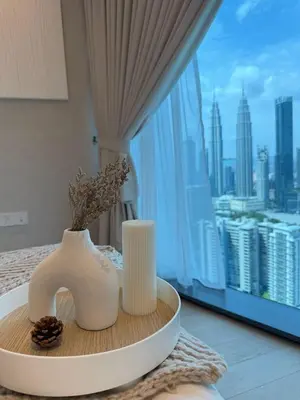 a table with two vases and a view of a city at Twin Tower Crush by KF in Kuala Lumpur