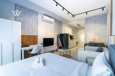 a bedroom with a bed and a living room at Modern & Minimalist Studio at Majestic Residence KL in Kuala Lumpur