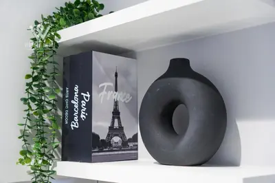 a black vase sitting on a shelf next to a book at Modern & Minimalist Studio at Majestic Residence KL in Kuala Lumpur
