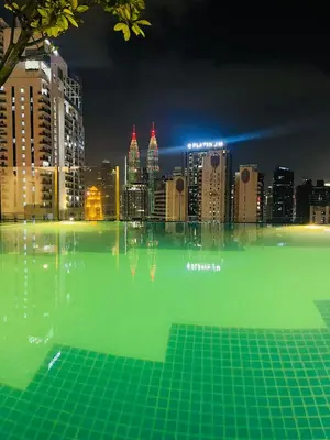 a swimming pool with a city skyline at night at Majestic Residence Kuala lumpur by Luxury in Kuala Lumpur