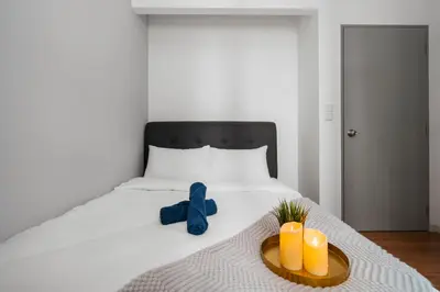 a bed with a blue ribbon and candles on it at M Vertica KLCC View IKEA Velocity in Kuala Lumpur