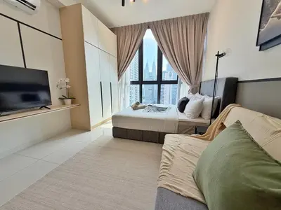a hotel room with two beds and a flat screen tv at KLCC View Majestic Cozy Studio with Rooftop Pool in Kuala Lumpur