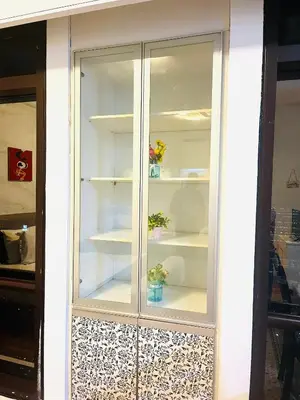 a white glass cabinet with flowers in it at Arba Suite Times Square KL in Kuala Lumpur
