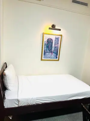 a bed in a room with a picture on the wall at Arba Suite Times Square KL in Kuala Lumpur