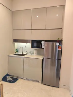 a kitchen with a stainless steel refrigerator and cabinets at Studio Apartment Lucentia Residence in Kuala Lumpur