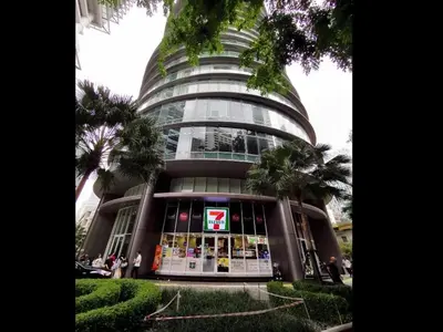 a tall glass building with a sign in front of it at Garden City of Lights Vortex Suites in Kuala Lumpur