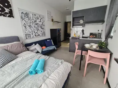 a room with a bed and a table and a kitchen at Stylish Studio Neu Suites 10 mins to KLCC in Kuala Lumpur