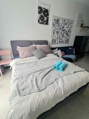a large bed with two blue slippers on top of it at Stylish Studio Neu Suites 10 mins to KLCC in Kuala Lumpur