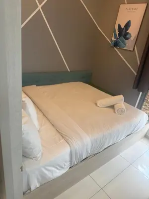 a bed with white sheets and a towel on it at Day Cocoon In City Kuala lumpur in Kuala Lumpur