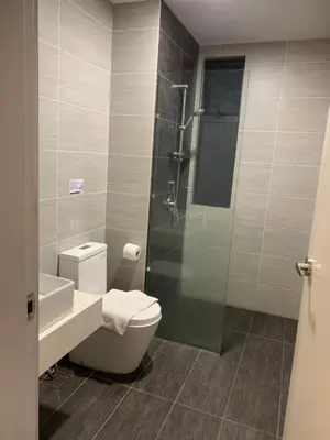 a bathroom with a toilet and a glass shower at Homestay at Trion KL in Kuala Lumpur
