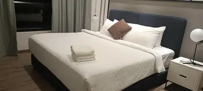a bedroom with a large bed with white sheets and pillows at Homestay at Trion KL in Kuala Lumpur