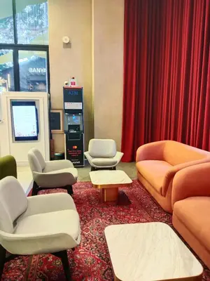 a waiting room with couches and chairs and a red curtain at SafeHouse At Scarletz Suite KLCC in Kuala Lumpur
