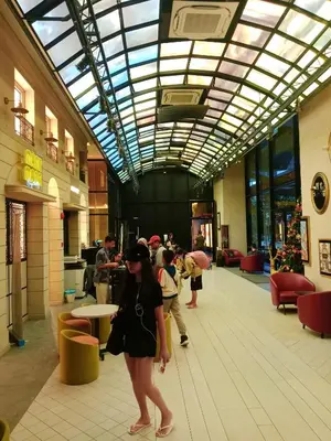 a woman walking through a shopping mall with people at SafeHouse At Scarletz Suite KLCC in Kuala Lumpur