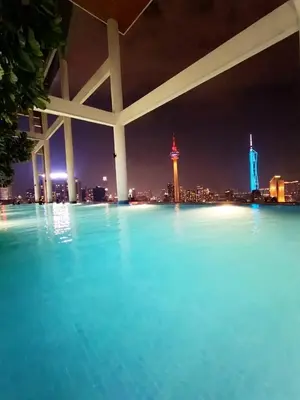 a swimming pool with a view of the city at night at The Luxe Colony By Kuala Lumpur Homestay in Kuala Lumpur