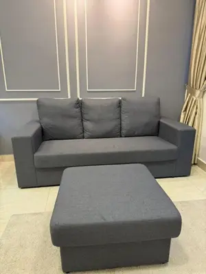 a grey couch with a ottoman in a living room at The Luxe Colony By Kuala Lumpur Homestay in Kuala Lumpur