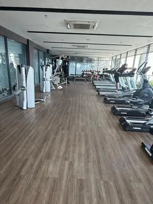 a gym with a row of treadmills and exercise machines at The Luxe Colony By Kuala Lumpur Homestay in Kuala Lumpur