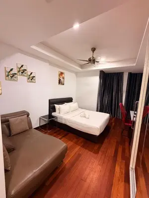 a bedroom with two beds and a couch in it at Casa Residency RH Homes in Kuala Lumpur