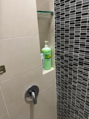 a bottle of green soap sitting on a shelf in a bathroom at Casa Residency RH Homes in Kuala Lumpur
